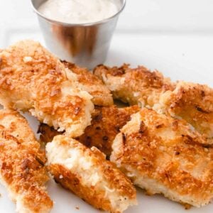 Plate of coconut chicken strips with a ramekin of ranch dressing