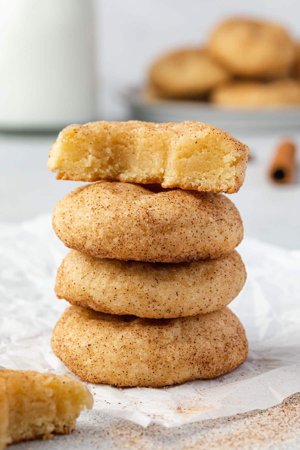 A stack of 4 thick snickerdoodle cookies. The top one has a bite out of it.