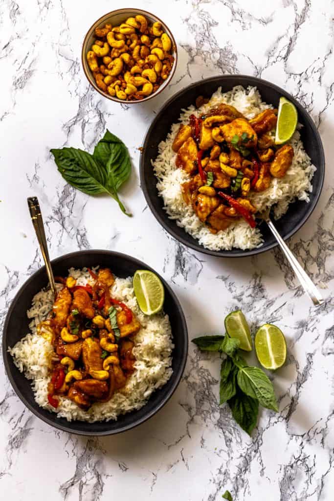 Two bowls of cashew chicken with small bowl of cashews