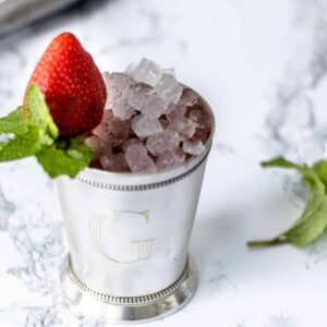 Strawberry mint julep with a whisp of mint on side.