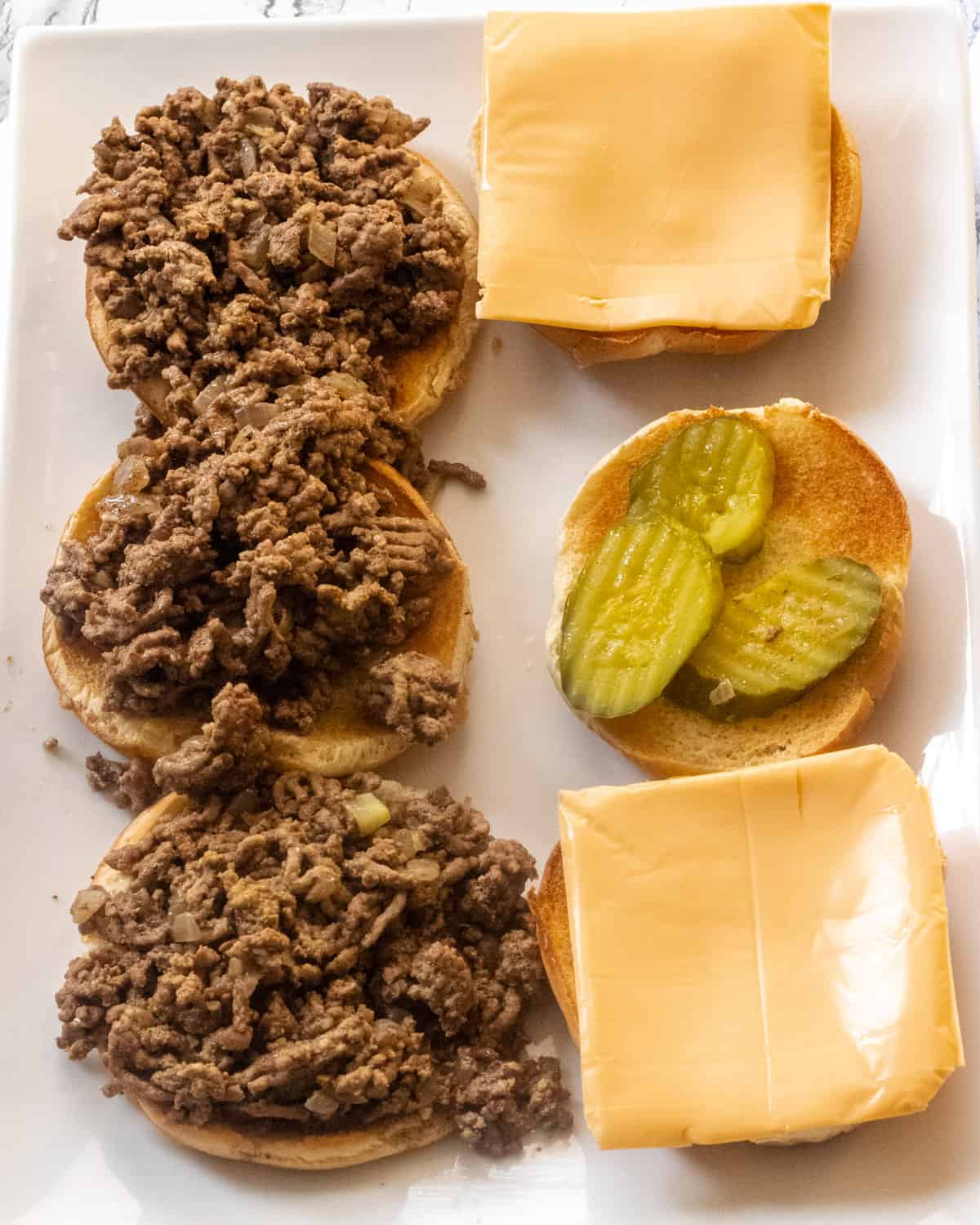 3 open-faced loose meat sandwiches, 2 with cheese, 1 with pickles