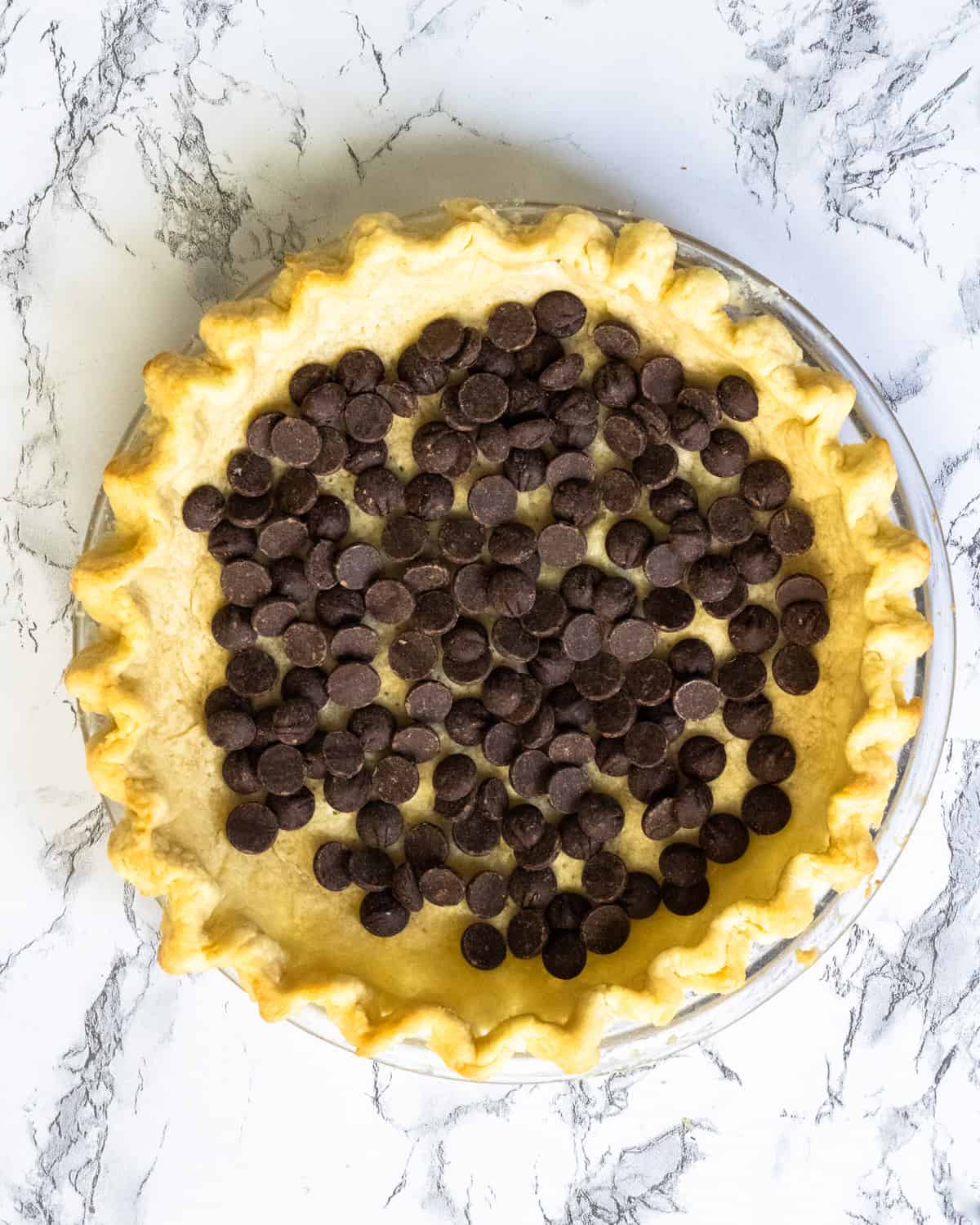Overhead shot of a pie with a layer of chocolate chips inside.