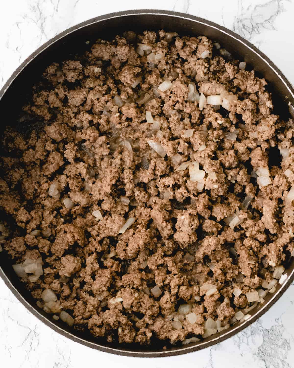 Cooked ground beef and onions in a pan.