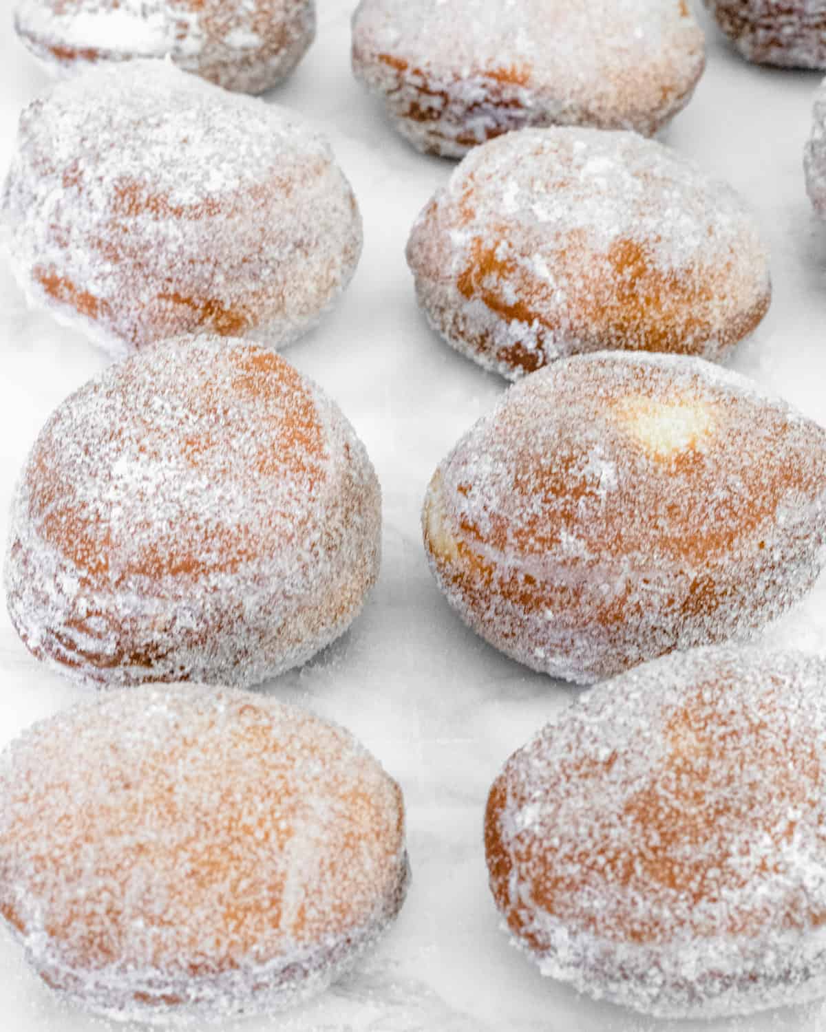 The paczki dough recipe is complete - two rows of sugar coated paczki.