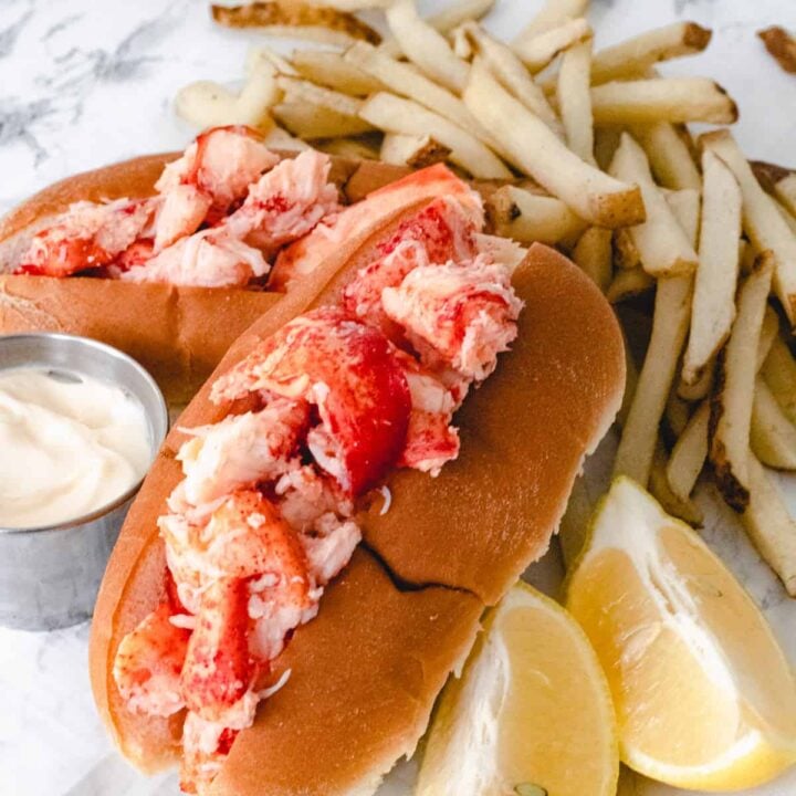 Famous food from Maine: Two lobster rolls with fries, mayo, and lemons.