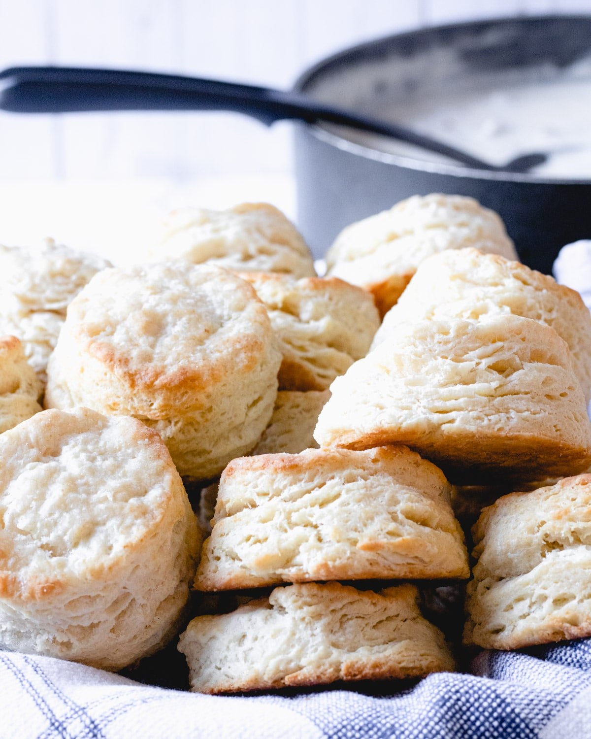 Basket of buttermilk biscuits with can of sausage gravy in background.