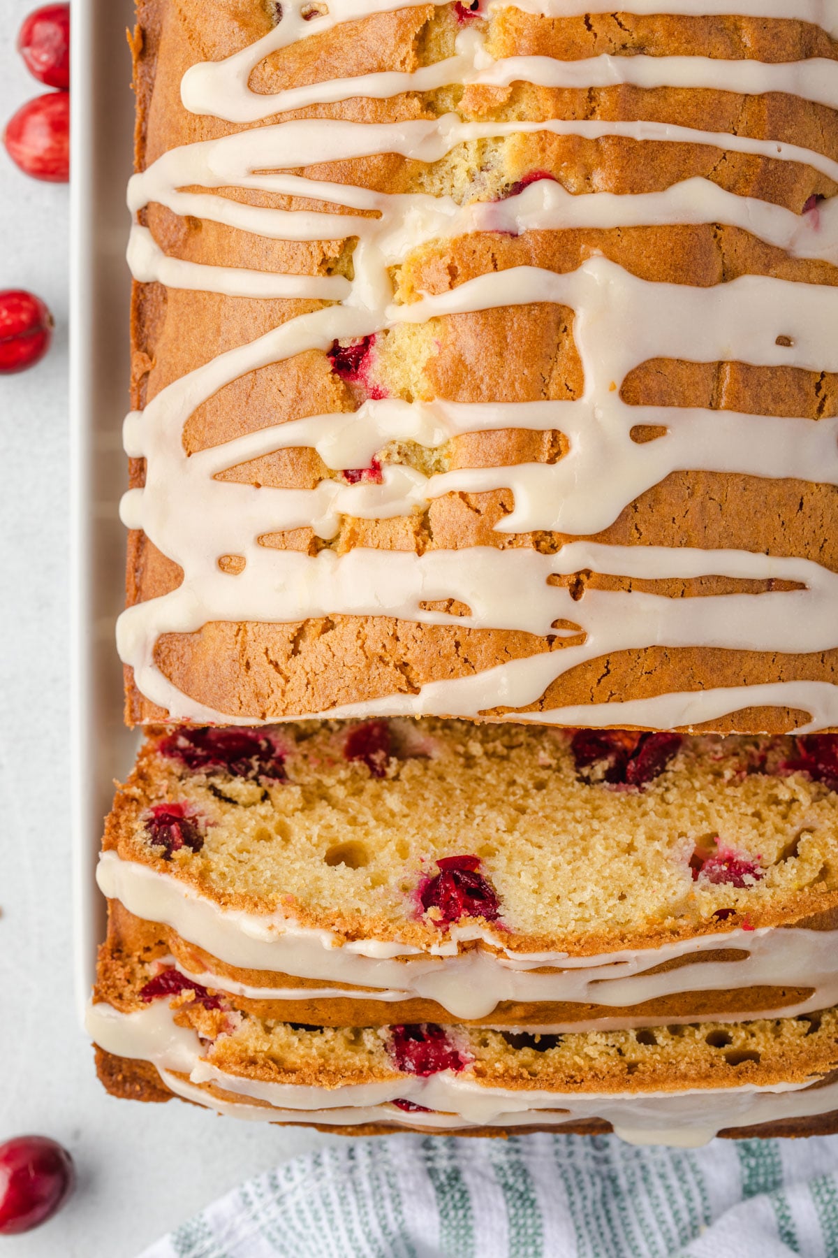 Overhead of cranberry loaf with glaze and 2 slices lying forward.