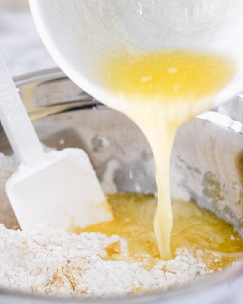 Pouring butter into cake mix.