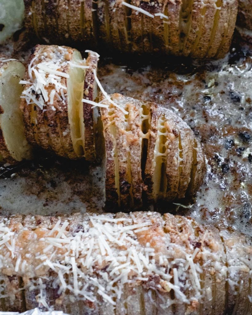 Roasted hasselback potatoes sprinkled with Parmesan cheese.