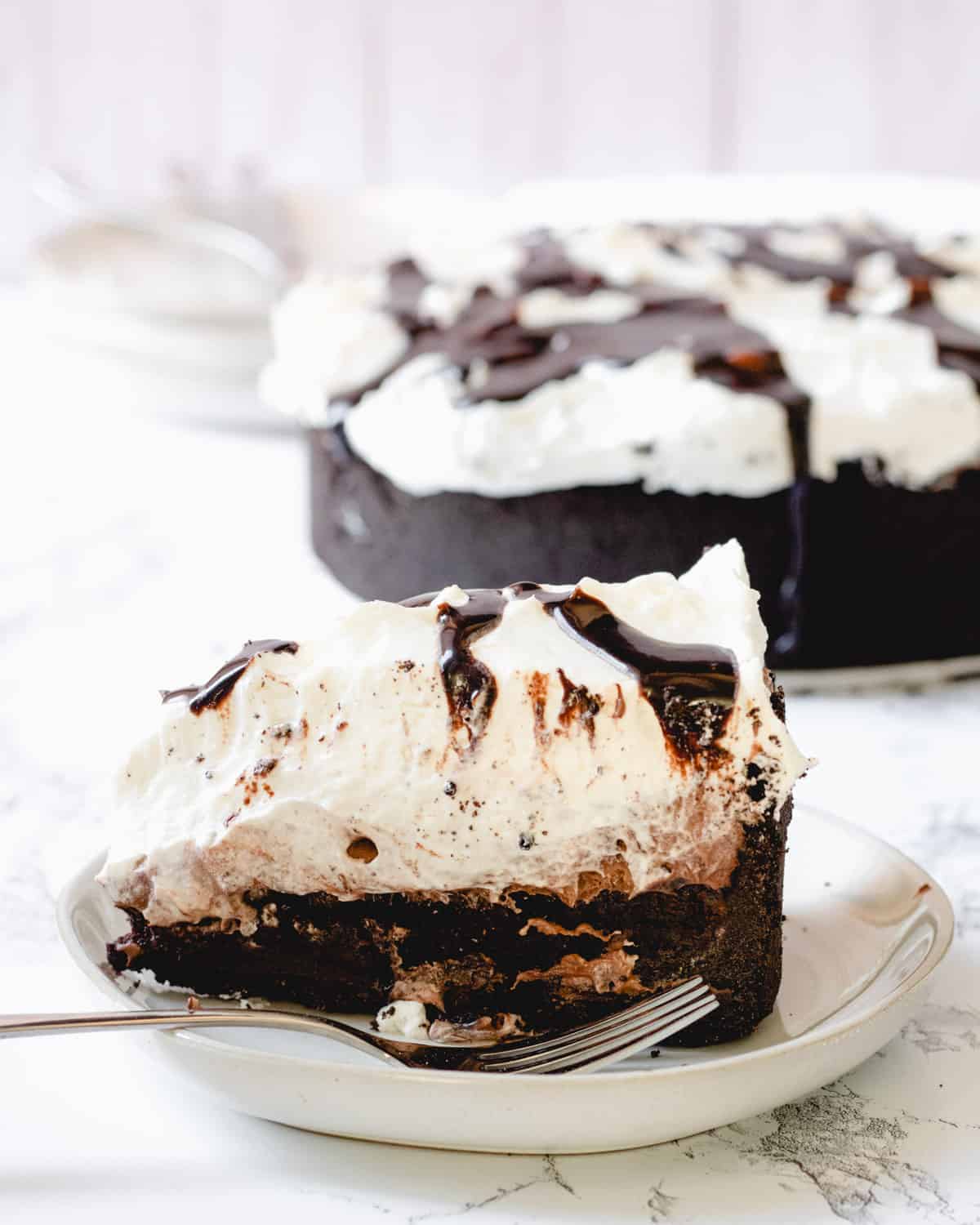 Slice of Mississippi Mud pie with the whole pie in the background.