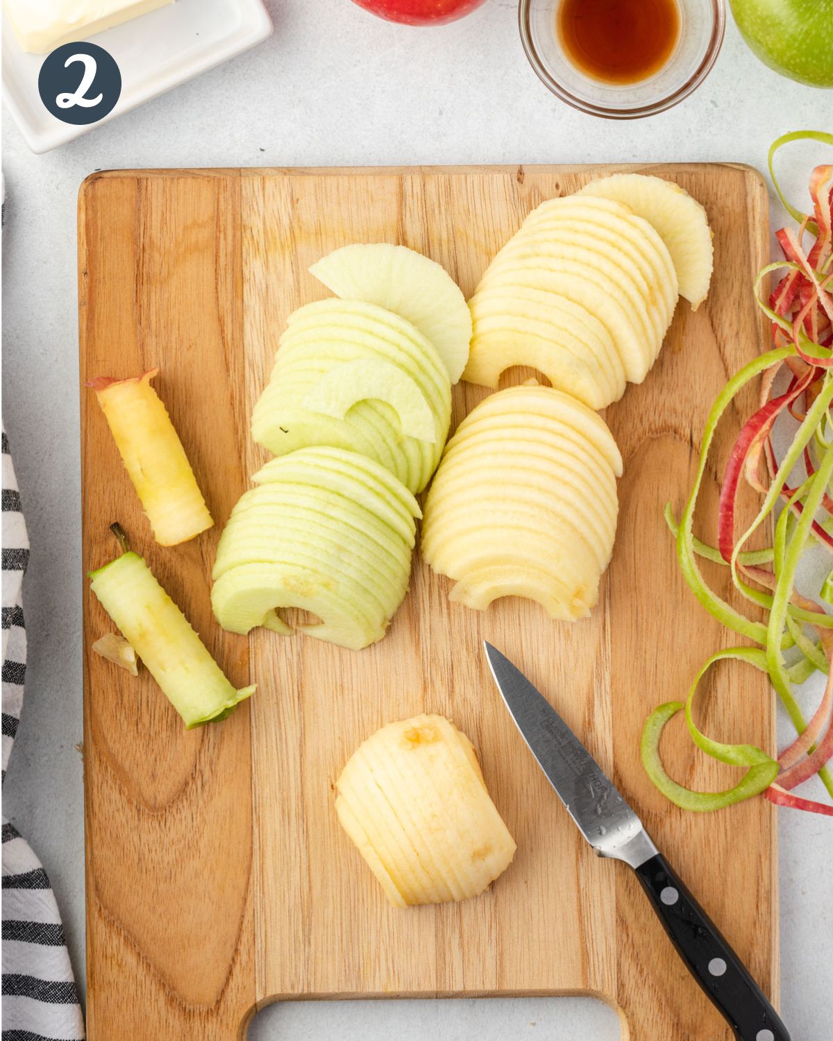 Two peeled apples sliced on a wooden cutting board.