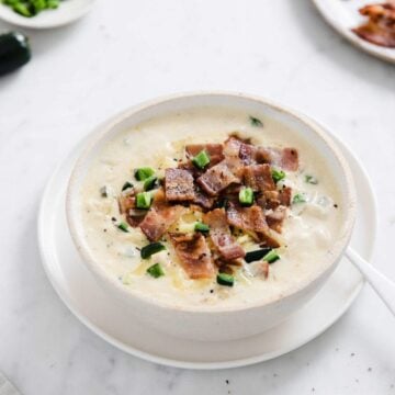 bowl of creamy jalapeno popper chicken soup with bacon crumbles on top.