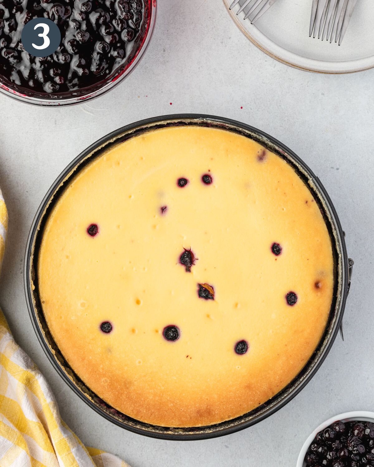 Baked cheesecake, golden brown edges with huckleberries showing.