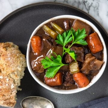 Bowl of beef stew garnished with parsley.