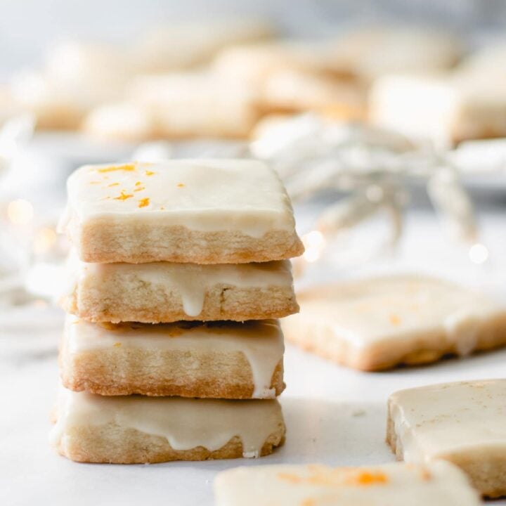 Stack of cardamom shortbread cookies with orange glaze.