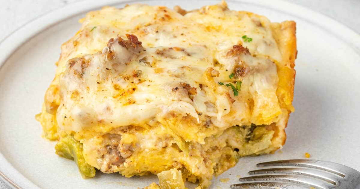 Close up of a cheesy egg and green chile casserole on a plate.