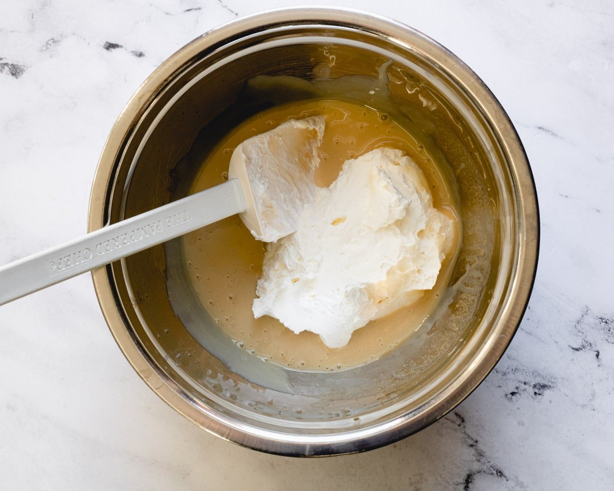1 cup of whipped cream added to bowl of condensed milk.