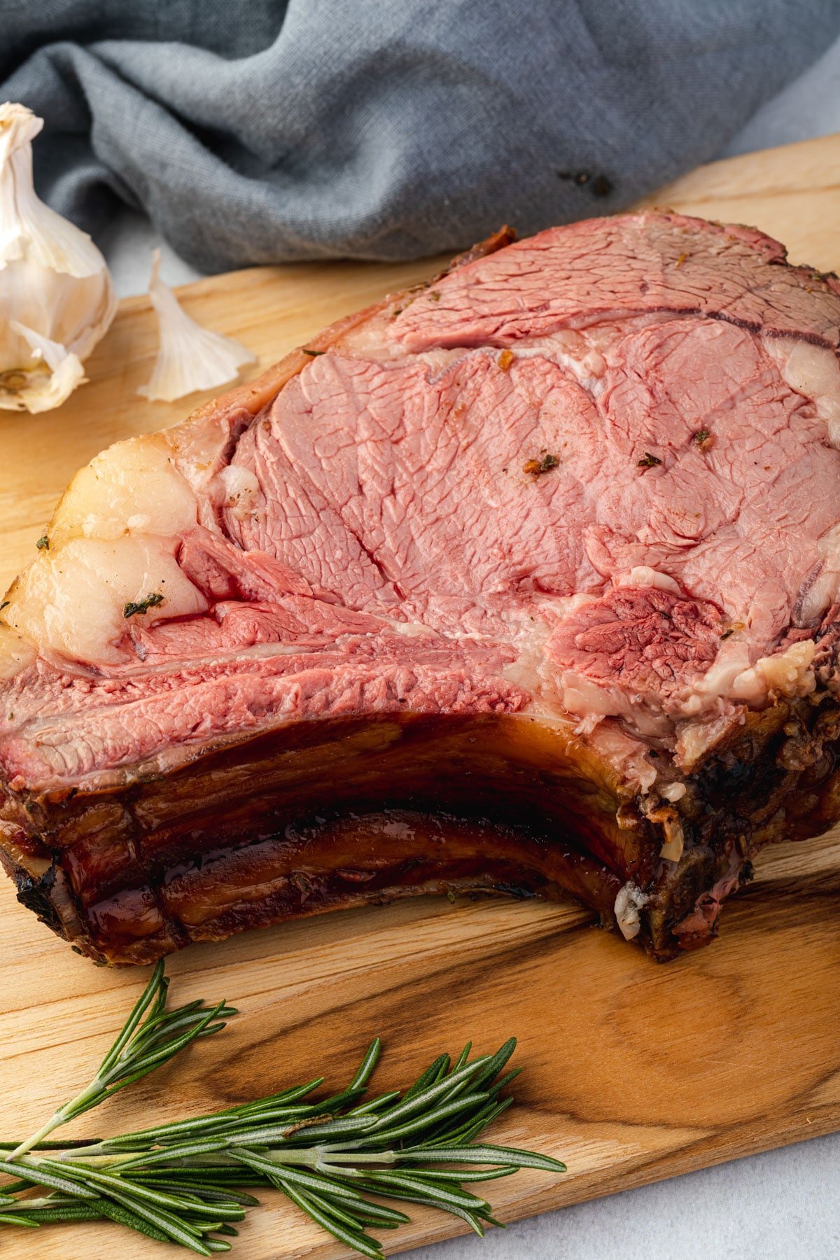 Slab of prime rib lying down on a wooden board.