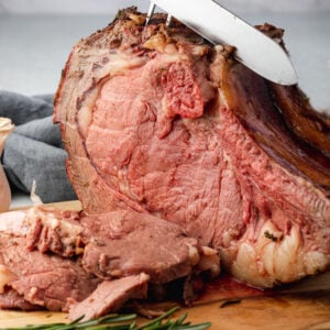 Carving the prime rib with carving knife and fork.
