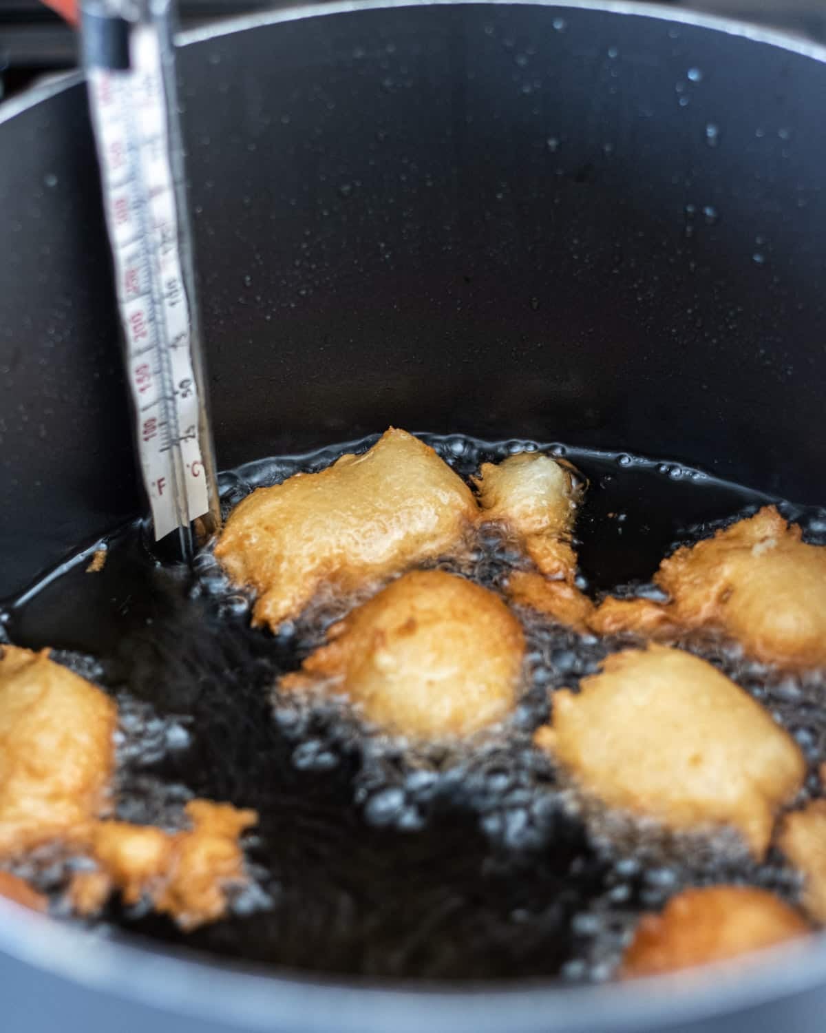 Funnel cake bites frying in oil.
