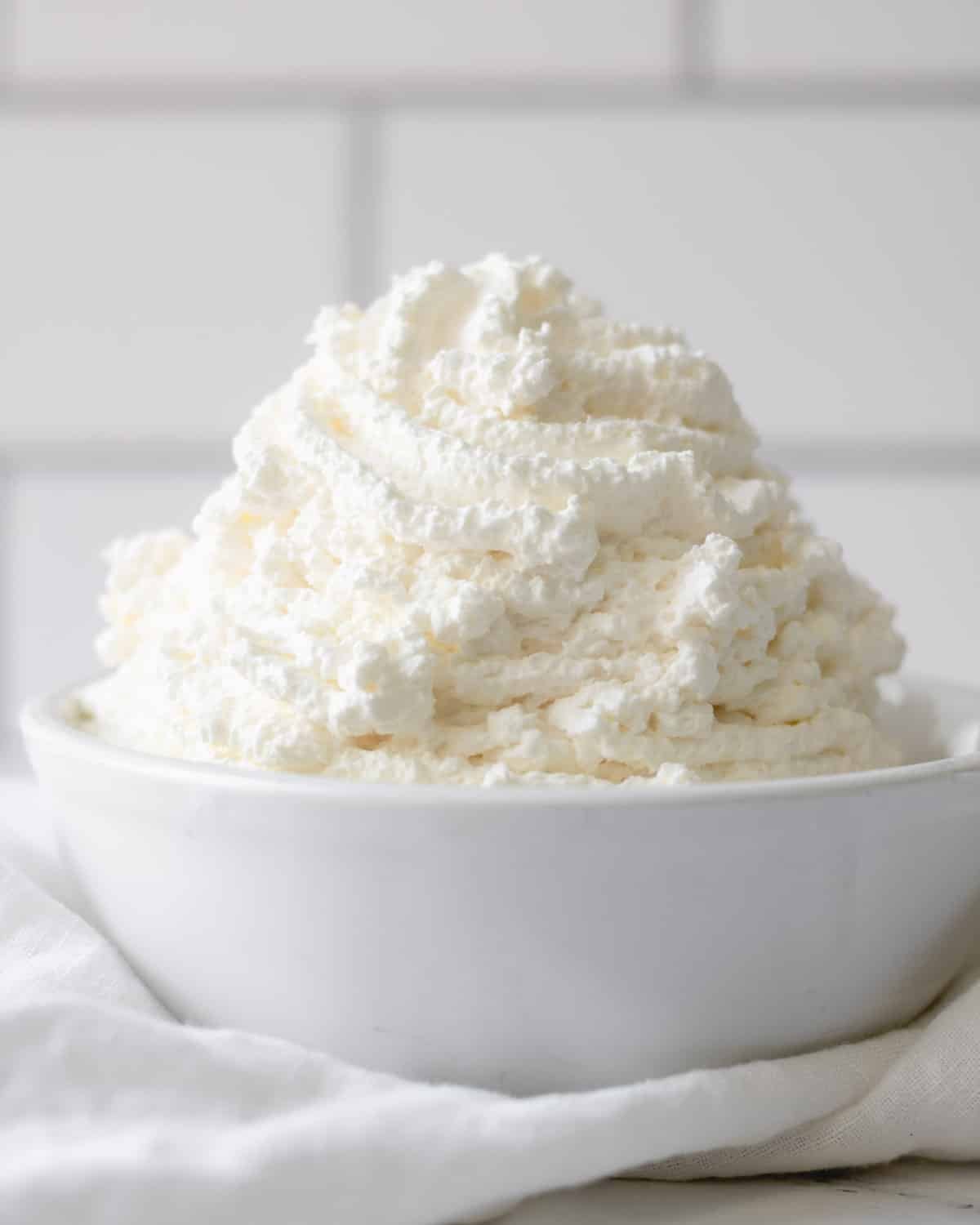 whipped cream piled into a bowl piled high.