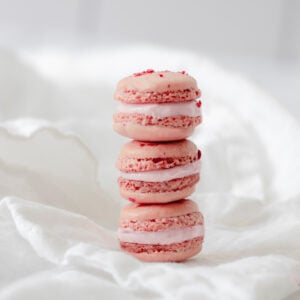 3 strawberry macarons stacked on top of each other.