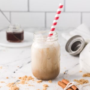 Brown sugar shaken espresso in a mason glass with a red and white striped straw.