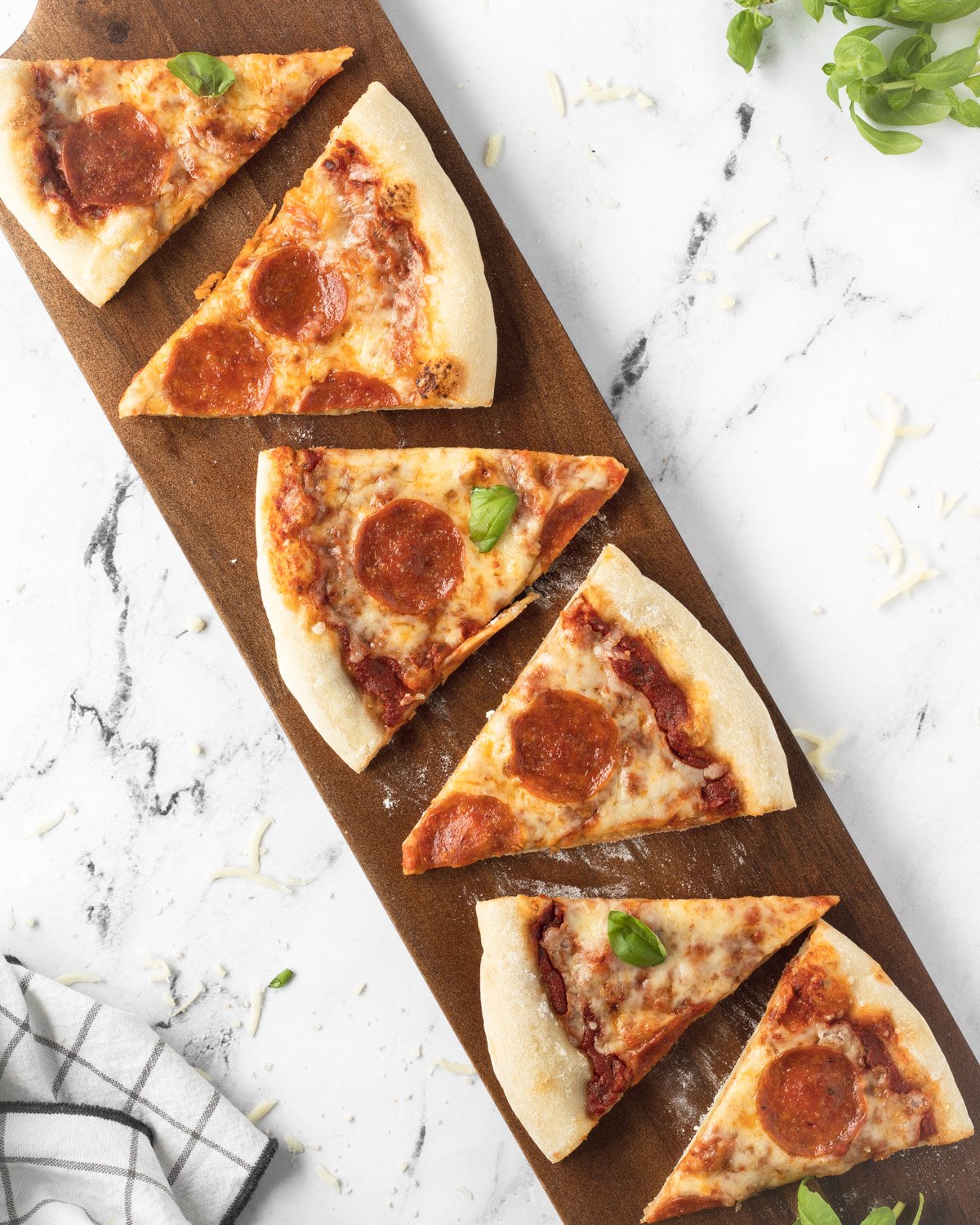 Pepperoni pizza slices on a wooden board.