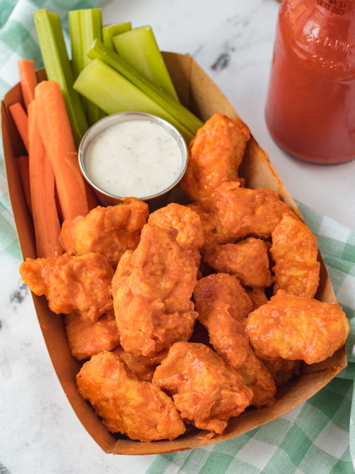 Basket of boneless buffalo wings, with celery, carrots, and ranch.