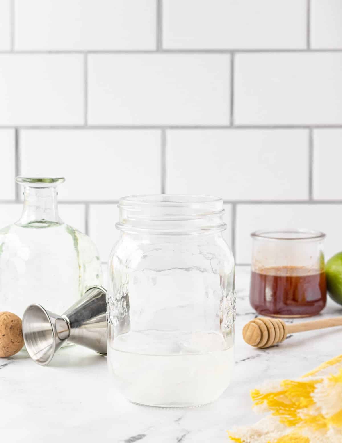 Mason jar with silver tequila added, and hot honey on the side.