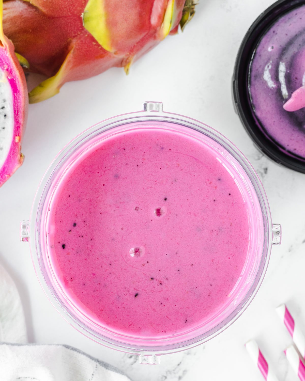 Overhead shot of pink blended smoothie in a blender cup.