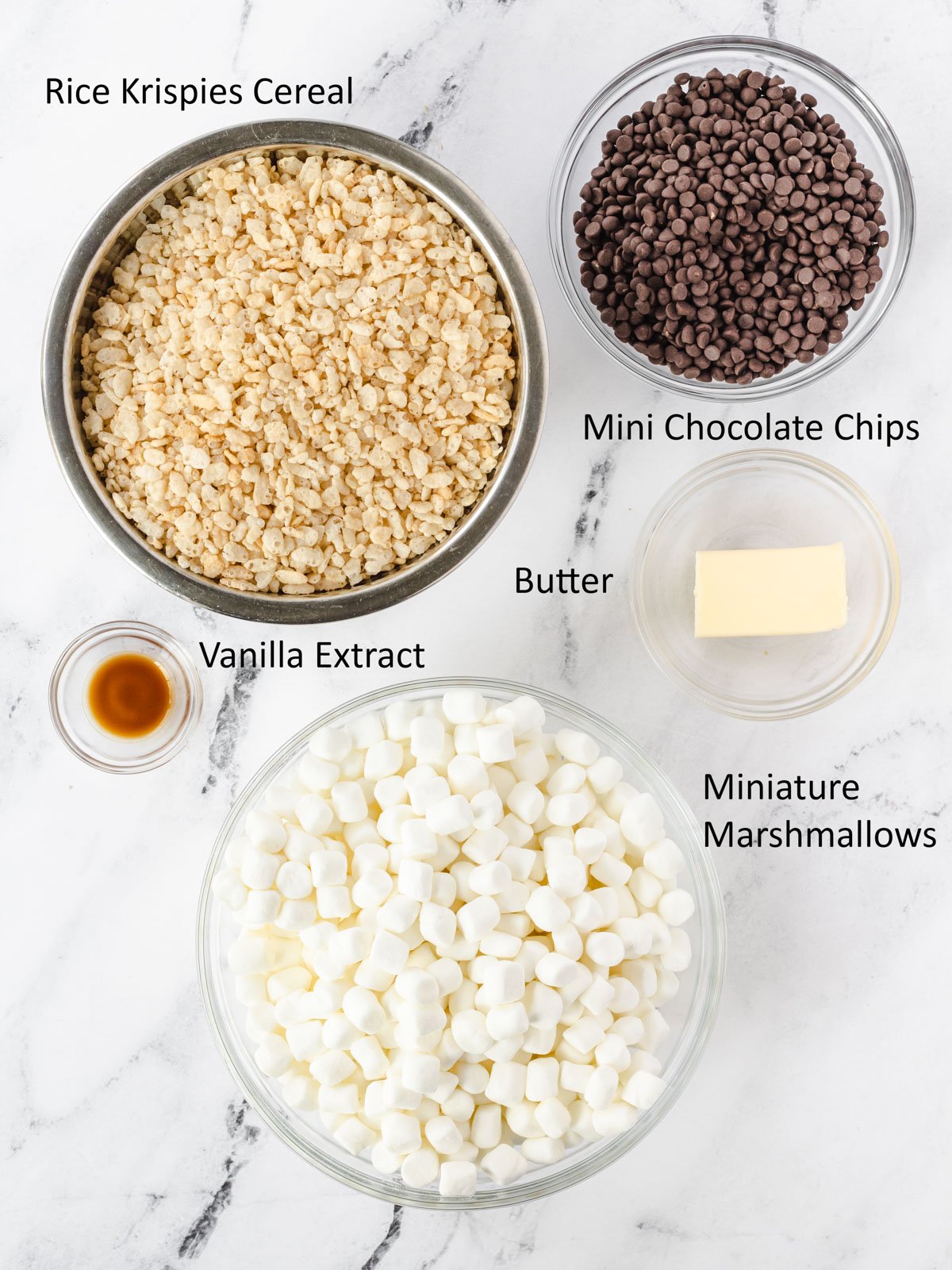 Labeled ingredients, cereal, chocolate chips, butter, marshmallows, and vanilla extract.