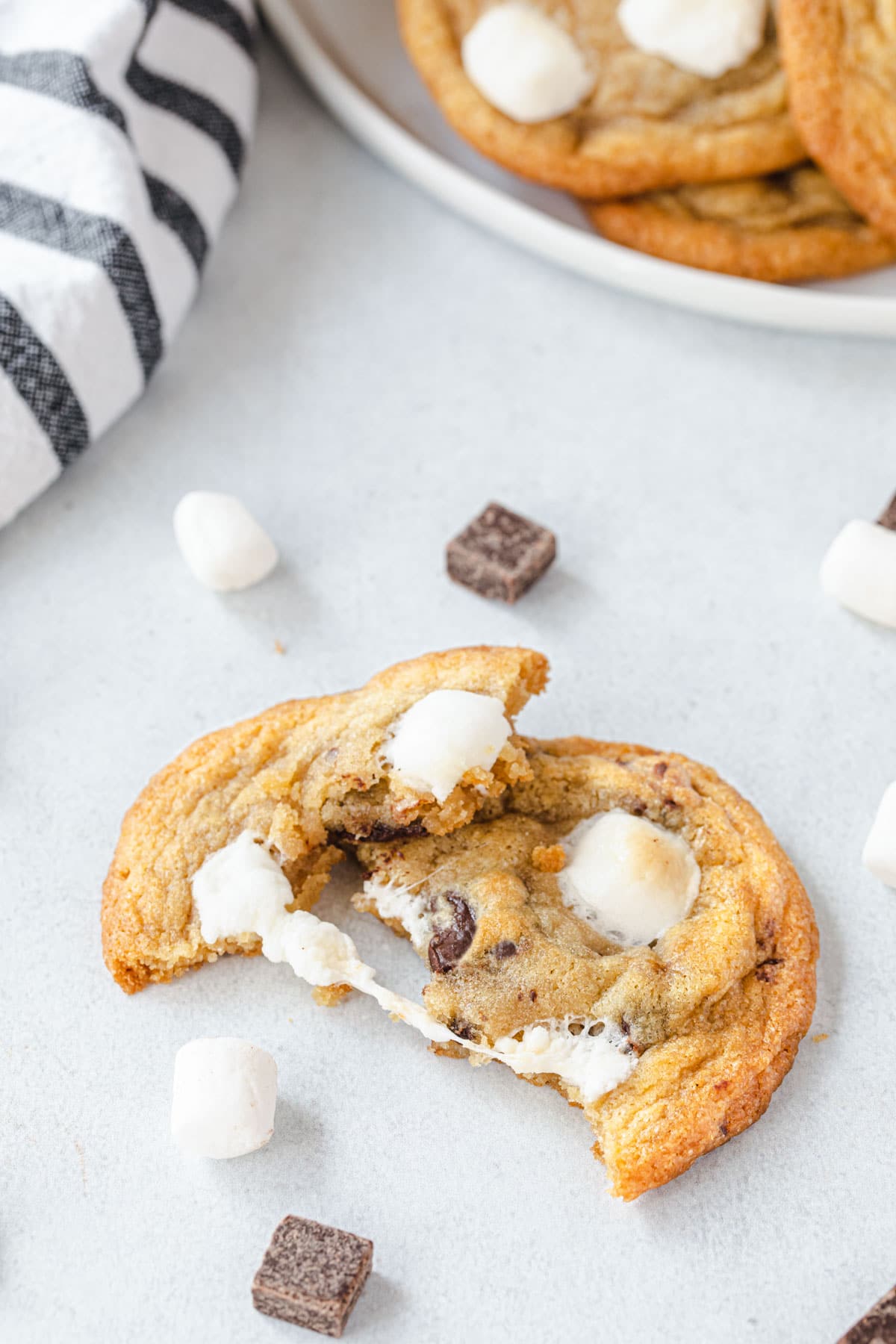 Cookie that is broken in half and gooey marshmallow is pulling between the two pieces.