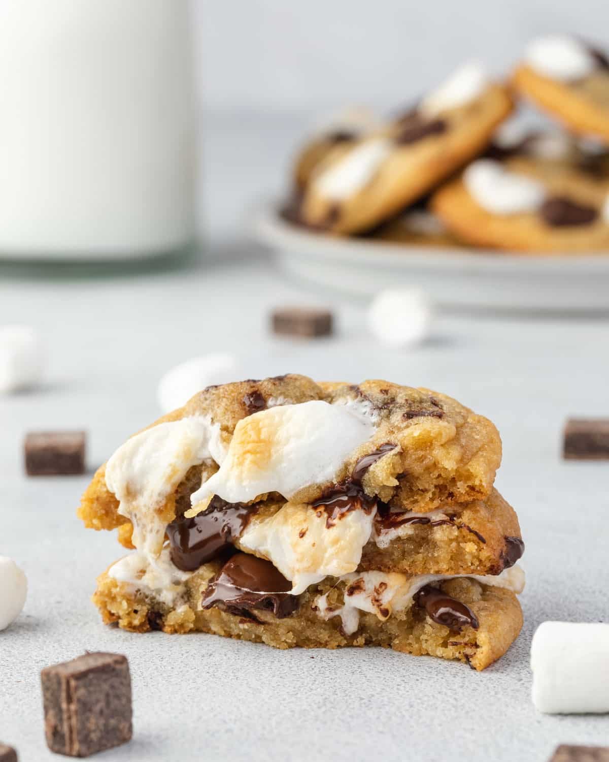3 halves of cookies stacked on each other with chocolate and marshmallow oozing down the stack.