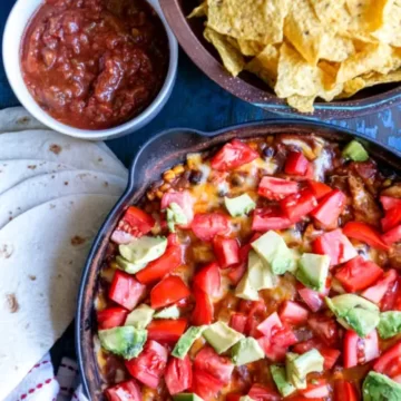Pan of chicken burrito skillet, with a bowl of chips and salsa.
