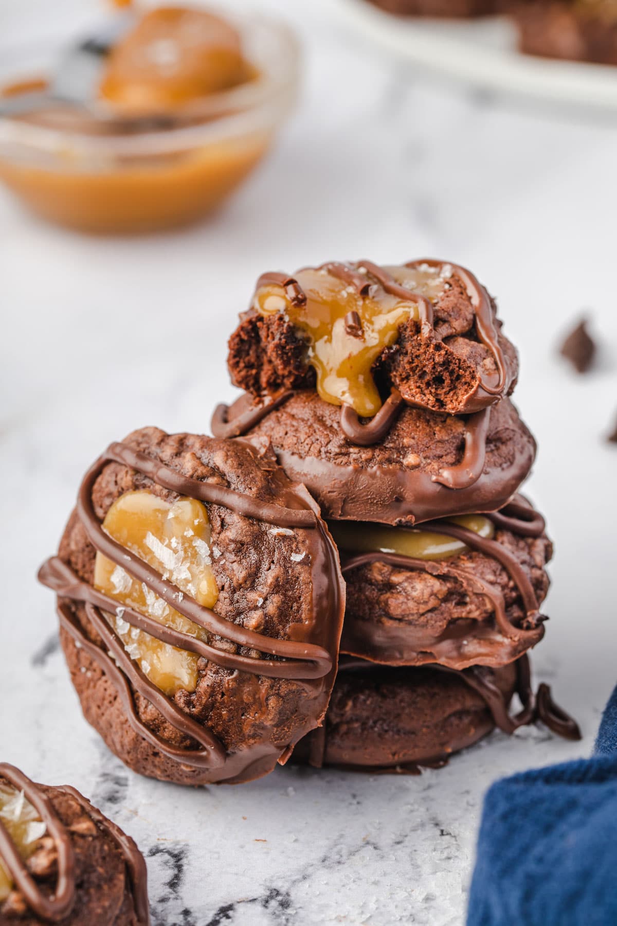 Stack of 4 caramel brownie cookies, with 1 on its side resting against the stack.