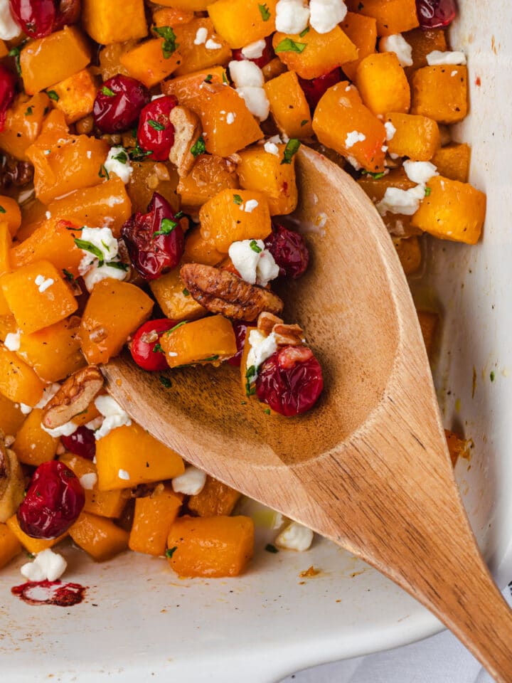 Close up of a wooden spoon scooping up the dish.