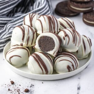 Plate of oreo balls with one sliced open.