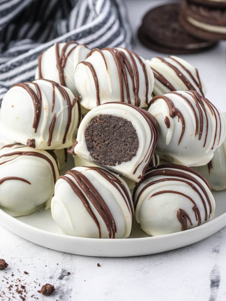 Plate of oreo balls with one sliced open.