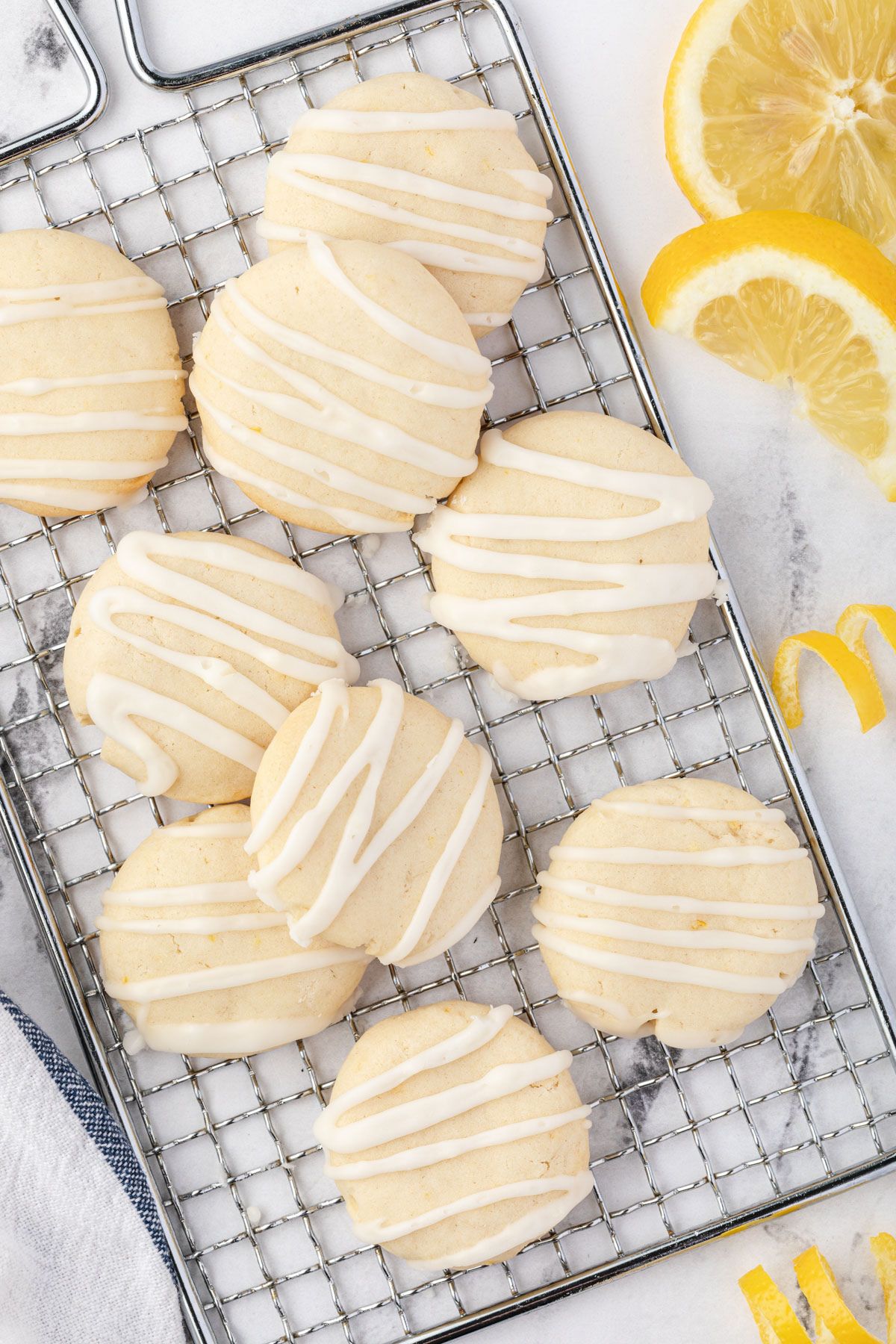 Cookies on a rectangular rack with lemon wedges in the corner.