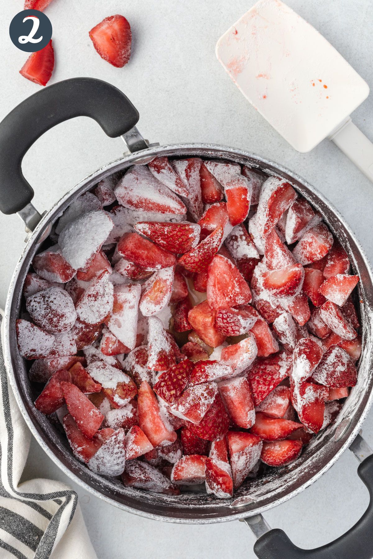 Strawberries ina  large pan coated with sugar and cornstarh mixture.