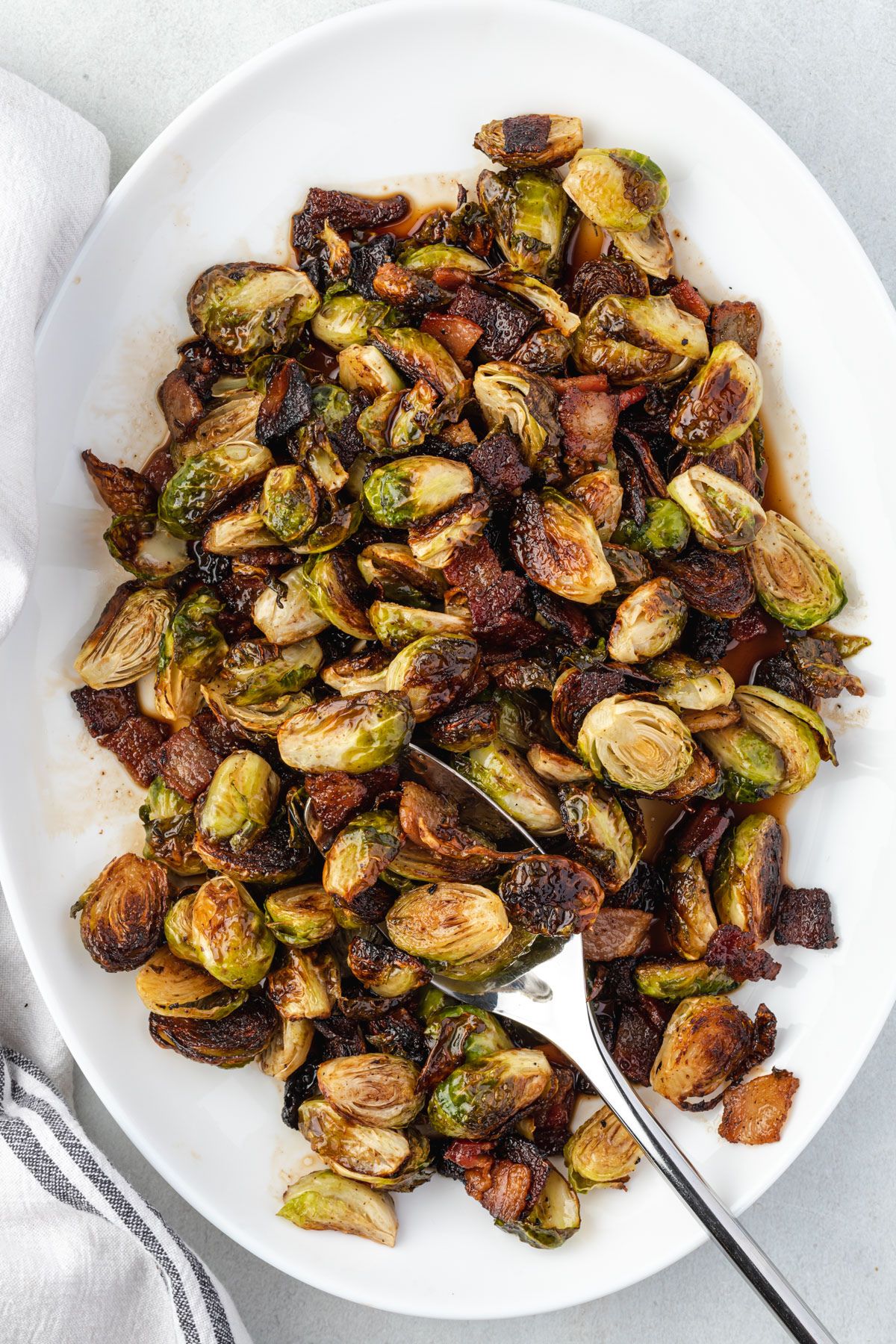 Overhead of the brussels sprouts tossed in maple balsamic sauce and on a platter.