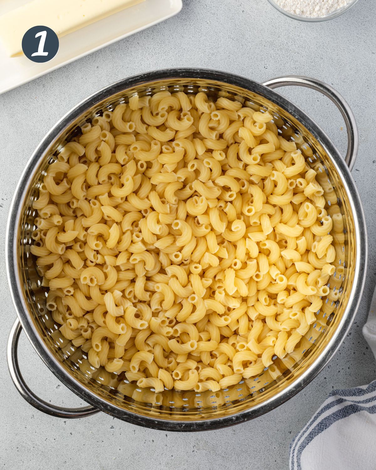 Macaroni noodles in a stainless colander.