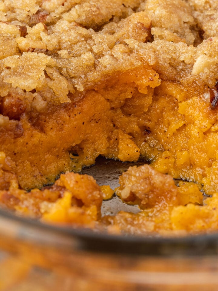 A pan of sweet potato crunch with a scoop missing.