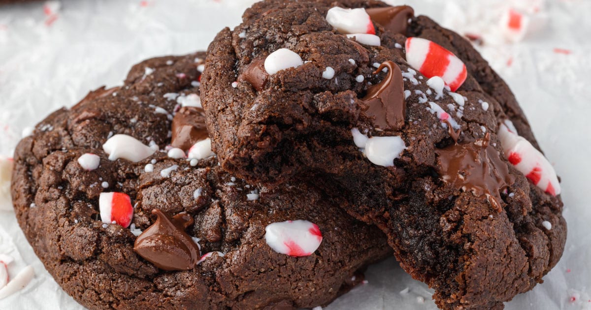 Two peppermint mocha cookies, one with a bite missing showing melty inside.