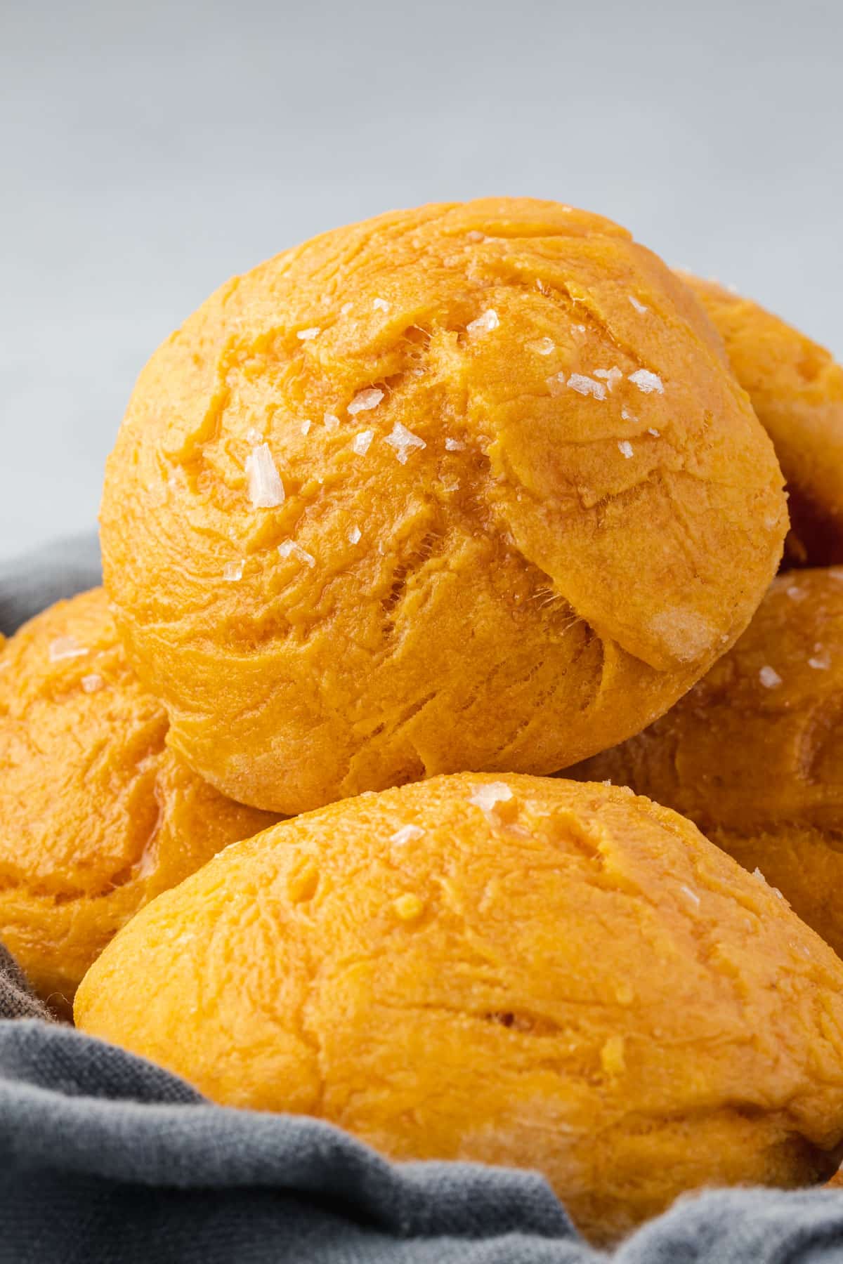 Close up of a basket of sweet potato rolls with sprinkles of sea salt on top.