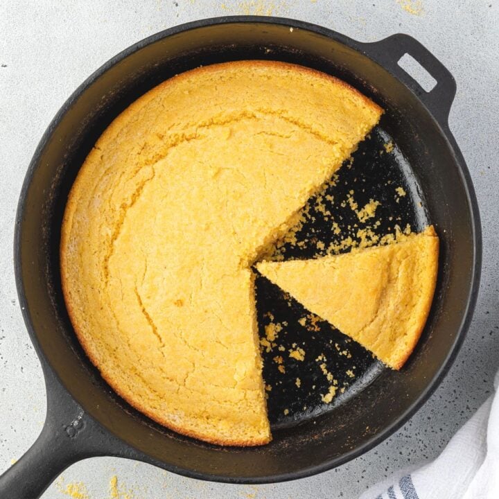 Overhead of southern cornbread in cast iron with 2 slices cut out.