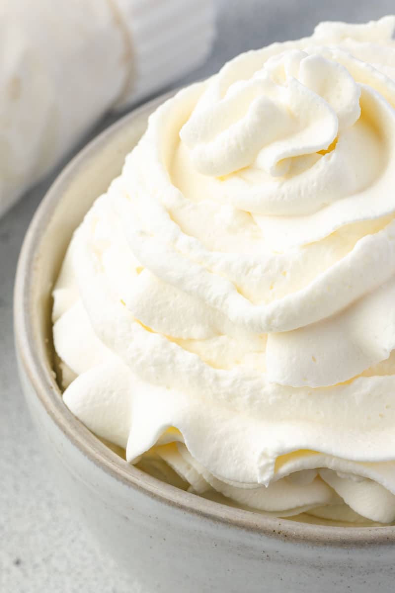 Close up on half a bowl of whipped cream.