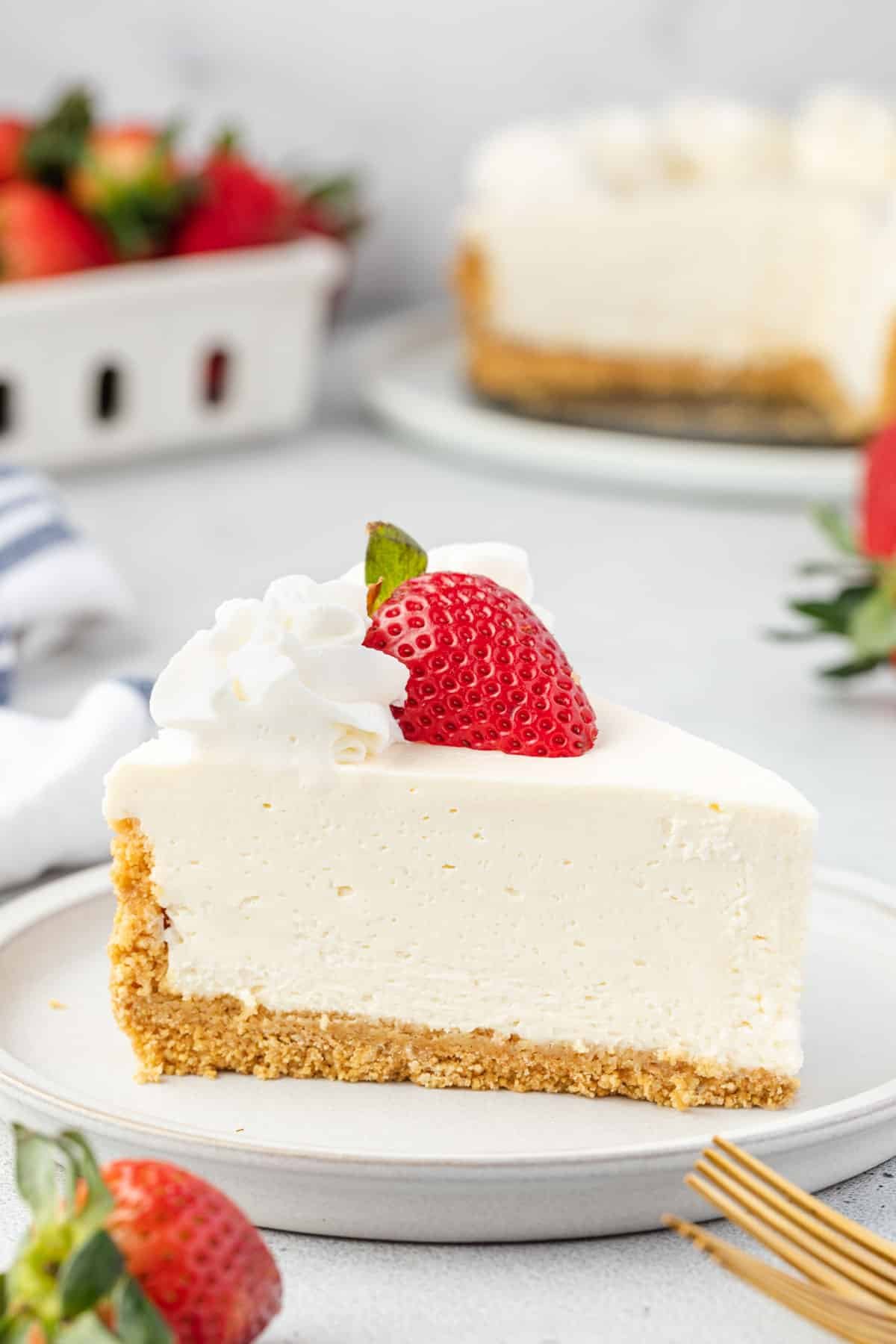 Side view of cheesecake on a plate showing creamy, smooth consistency.