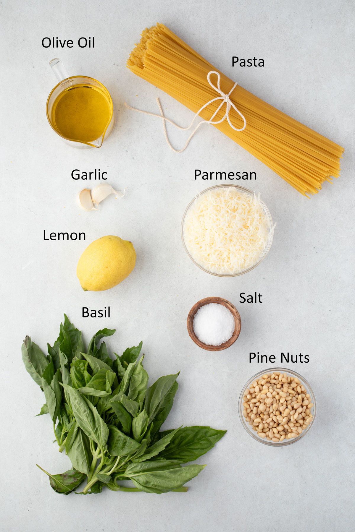 Overhead of ingredients with labels for lemon pesto pasta.